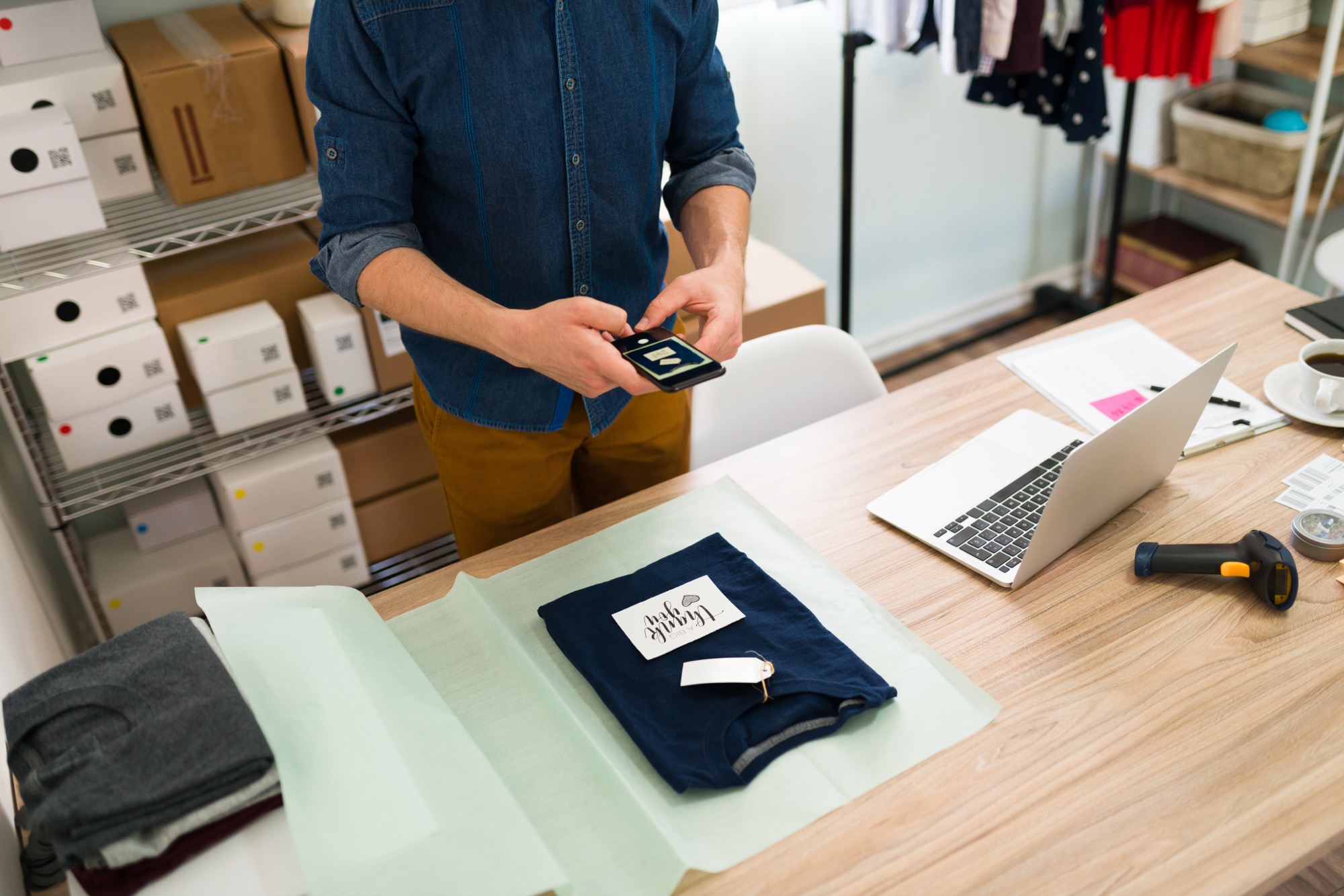 A boutique operator packing a customer order while reviewing inventory